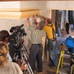 craftsmen install last piece of fireplace cornice while being filmed by the Met's filmcrew copy